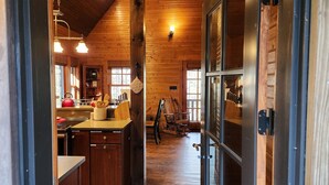A wooden interior with a kitchen area, wooden cabinets, and a dining table.