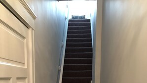 Una escalera con piso alfombrado que lleva a una plataforma.