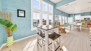 Una habitación amplia con ventanas grandes, un comedor y una cocina.