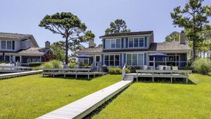 A coastal property with multiple decks, outdoor seating areas, and a wooden walkway leading to the entrance. - 9 Lands End Rd-Pretty view, Pool Onsite, Easy Walk to water & S. Beach Marina (Hilton Head Island)