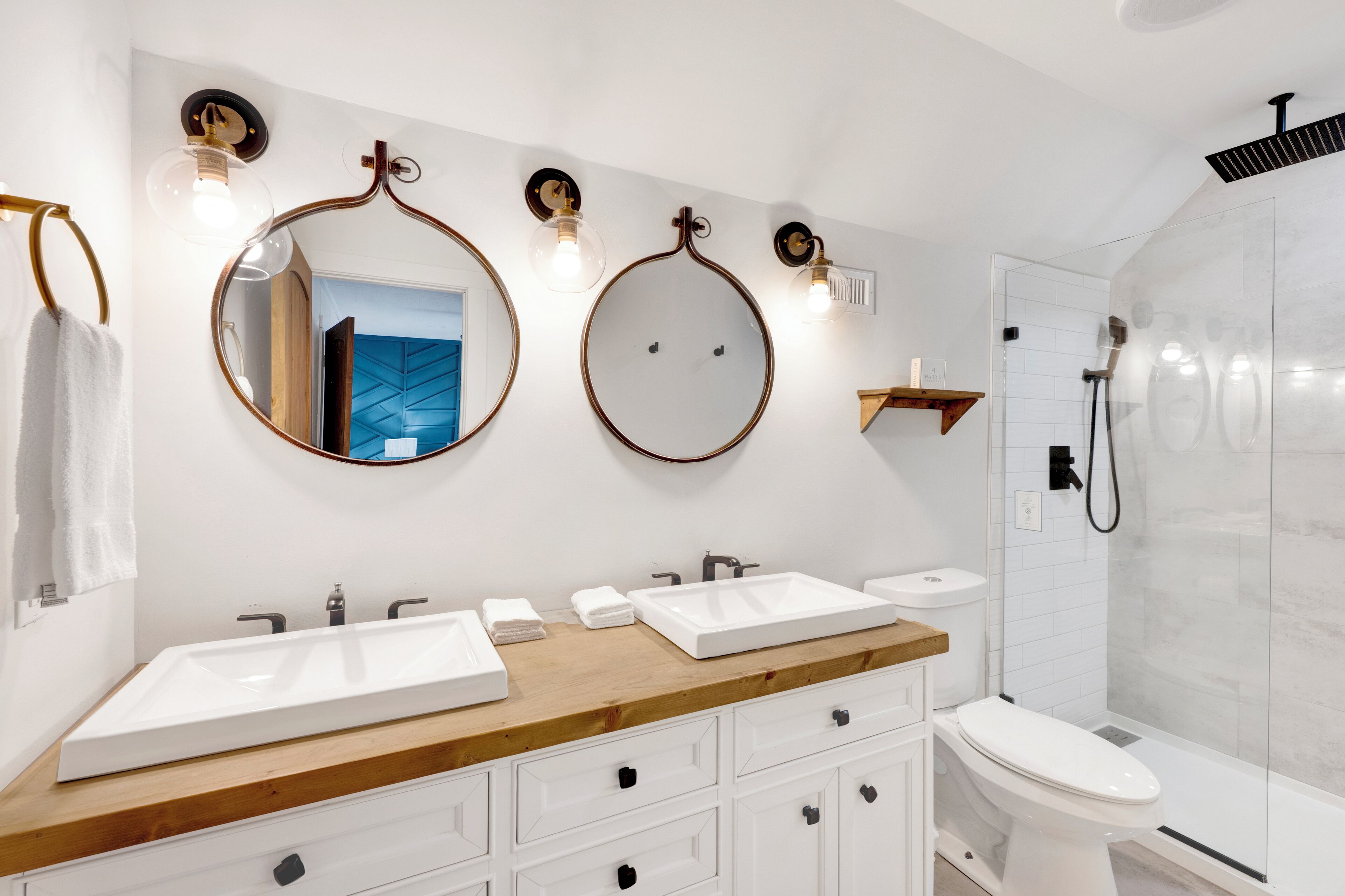 Un baño moderno con dos lavamanos, inodoro y ducha.