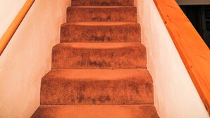 A wooden staircase with a red door at the top. - River Tranquility managed by Cabin Butler (Greer)
