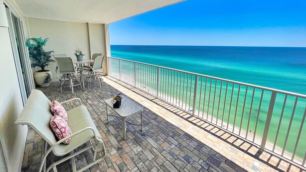 A balcony with a view of the ocean, a seating area with chairs and a table, and a potted plant. - Platinum Rated, Beach Front, Condo at Ocean Reef with Free Beach Chairs! (Panama City Beach)