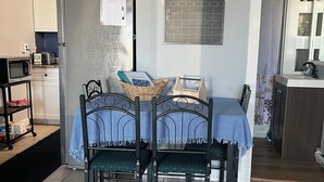 A dining area with a table and chairs, a microwave, a toaster, and a calendar on the wall. - Waterfront Condo Within Steps To Wells Beach!  (Wells)