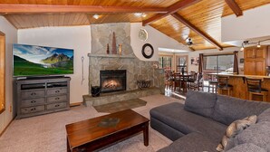 Una sala de estar acogedora con chimenea de piedra, televisor y un sofá cómodo.