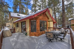 A cabin with a covered porch and a dining area.