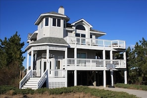 A two-story house with a balcony, a staircase, and a basketball hoop.