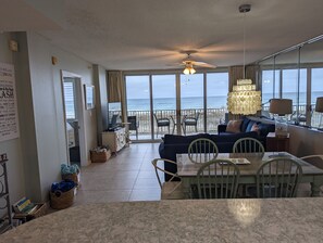 A spacious living room with a large window overlooking the beach, a ceiling fan, and a dining area with a table and chairs. - Breathtaking views directly facing the Gulf!  3bd/3bath/6 (Fort Walton Beach)