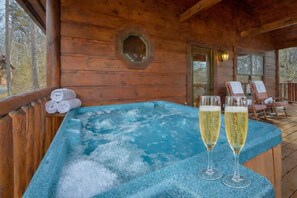 Una baita di legno con vasca idromassaggio e poltrone relax.