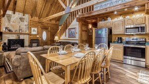 L’intérieur d’un chalet confortable en bois, avec un coin repas, une cuisine et un salon.