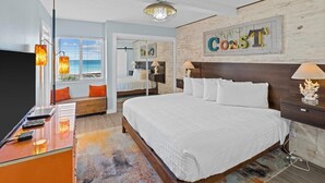 A hotel room with a large bed, a desk with a TV, a window with a view, and a wall with a 'Coast' sign. - 321- Amazing Unit with Gorgeous View of the Gulf & Free Beach Service (Destin)