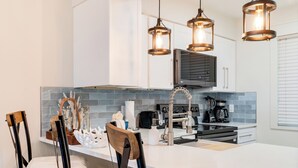 A modern kitchen with a central island, stainless steel appliances, and pendant lighting. - 🌅 Islander #201 – Sunrise Views & Steps to Destin’s Emerald Waters! 🌴 (Destin)