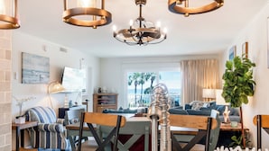 A modern kitchen with a central island, pendant lighting, and a view of the ocean. - 🌅 Islander #201 – Sunrise Views & Steps to Destin’s Emerald Waters! 🌴 (Destin)