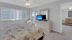 Une chambre à coucher comprenant un lit, une télévision, une commode et une chaise.