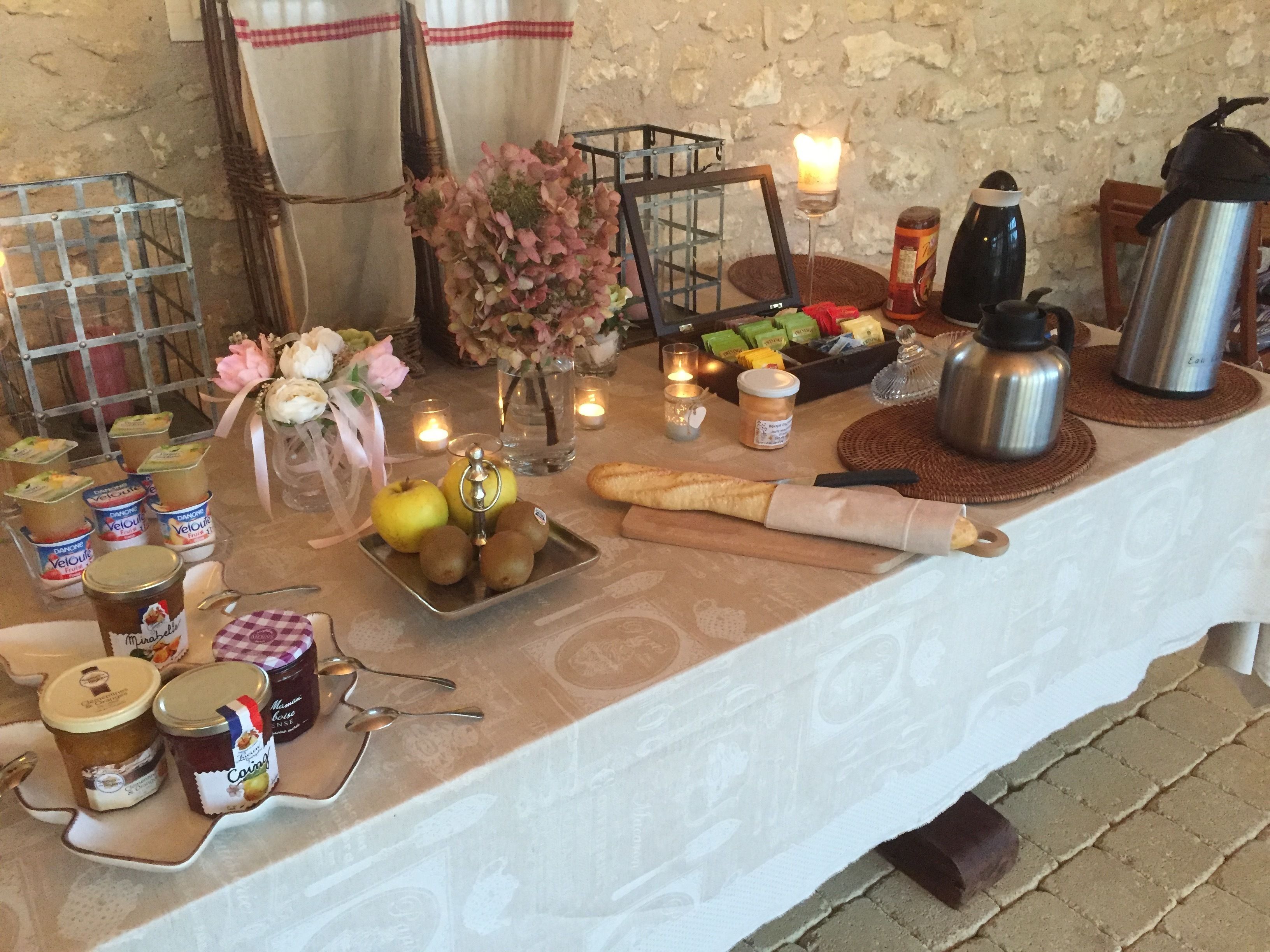 A table with various food items, candles, and a bouquet of flowers.