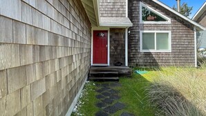 A house with a red door, a small porch, and a chimney.