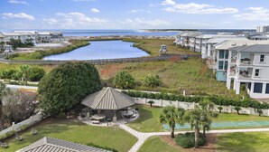 A coastal residential area with a large body of water, a gazebo, and a tennis court. - Coastal Comfort & Resort Fun – Islander 613 (Destin)