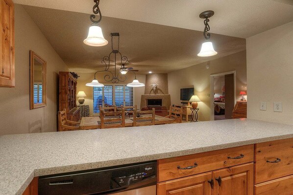 A kitchen with a dishwasher, wooden cabinets, and pendant lighting. - Cactus Retreat Modern 2 bedroom Condo/ Community Pool/ Great Location in Scottsdale (Scottsdale)