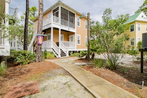 A two-story building with a balcony, a covered porch, and a staircase leading to the entrance.