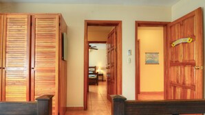 A hallway with wooden doors, a bed, and a ceiling fan. - Heaven On Earth! Perfect Get-Away! Gorgeous Beach. Pool. Couples &/or Families. (Samara)