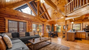 Ein Holzblockhaus mit Wohnzimmer, Essbereich und Küche.