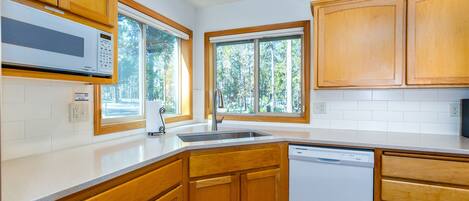 A kitchen with wooden cabinets, a built-in microwave, and a dishwasher.
