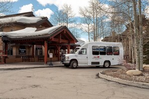 A white van parked in front of a building with a 'Check-In Office' sign.