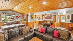 Una habitación acogedora con un sofá de cuero, una mesa de centro de madera y una mesa de fútbol.