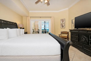 Une chambre d’hôtel avec un grand lit, une télévision, une commode et une vue sur l’extérieur.