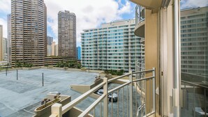 A high-rise building with a parking area and a balcony. - Experience the vibrant energy of Waikiki, featuring city views and close to beach! (Honolulu)