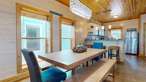 A wooden interior with a dining area, kitchen, and a sign reading "Beach House". - Townhome Located in Town, Close to beach, Shared Pool, Pet Friendly (Port Aransas)