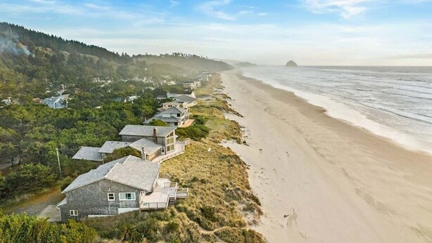 A coastal property with multiple houses along a beach, featuring a mix of modern and traditional architecture, surrounded by natural vegetation and a clear view of the ocean. - la Playa Luna-Family sized beachfront home (Cloverdale)