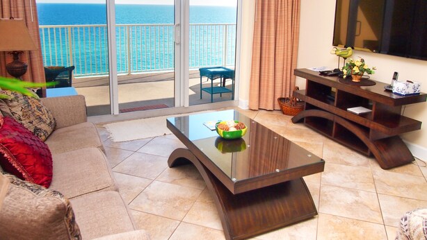 Un salon doté d’une porte vitrée donnant sur un balcon avec vue sur la mer.