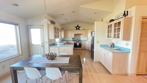 Una cucina moderna con isola centrale, mobili bianchi e piano di lavoro blu.