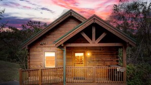 Une cabane en bois avec un porche, une porte bien visible et une enseigne indiquant « Auberge de l’Aigle ».