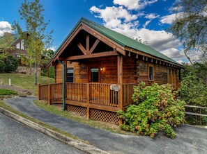 A rustic log cabin with a green roof, a wooden porch, and a sign indicating it is Eagle's Perch. - ERN812 - Eagles Perch-2bd 2.5bth in Pigeon Forge! (Pigeon Forge)