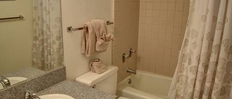 A bathroom with a sink, toilet, and bathtub.