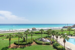 Un resort con piscina, palmeras y vista al mar.