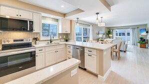 Een moderne keuken met inbouwapparatuur, een eethoek en uitzicht op de stad.