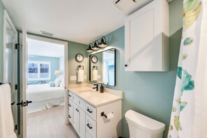 Ein Badezimmer mit Toilette, Waschbecken und Spiegeln.