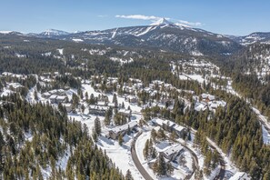A snow-covered mountain town with buildings surrounded by dense forests.