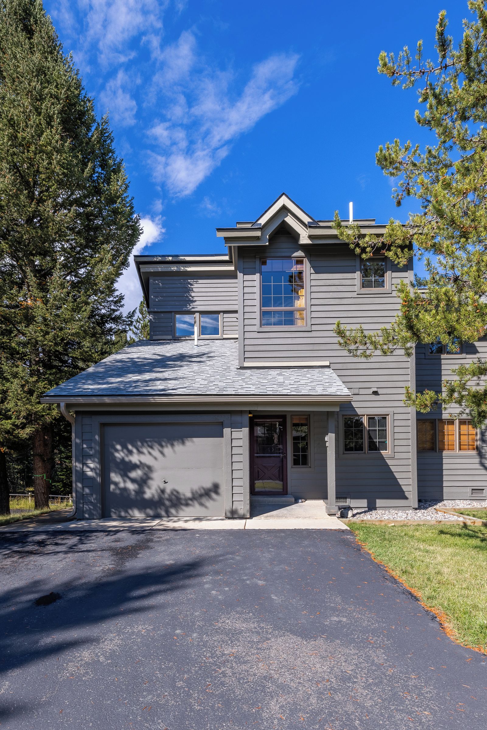 Een woonhuis met twee verdiepingen, een garage, een voortuin en een oprit.