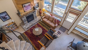 A spacious living area with a fireplace, leather sofa, and a dining table with chairs. - Beautiful home w/fireplace, amazing views & community hot tub - Hidden Village Cozy Getaway (Gallatin Gateway)