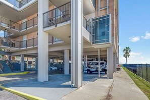 Un aparcamiento de varios pisos con un pasillo cubierto y un edificio con balcones.