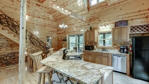 L’intérieur d’une cabane en bois comprend une cuisine, un coin repas et un escalier.