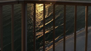 Tramonto sull'oceano con vista sul mare e una ringhiera in primo piano.