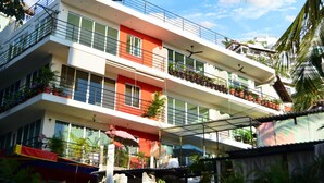 Un hotel de varios pisos con balcones, ventanas amplias y zonas de estar al aire libre.