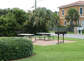 Un cortile con tavoli da picnic e una cassetta delle lettere.
