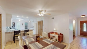 A spacious dining area with a large table, chairs, and a ceiling fan. - Grace Cottage 3 bedrooms, 2 bathrooms (Jekyll Island)