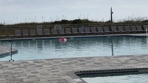 A swimming pool with lounge chairs and a lifeguard sign. - Oceanside Resort! King Master Suite, Sleeps 6, Walk to the Beach! (Hilton Head Island)